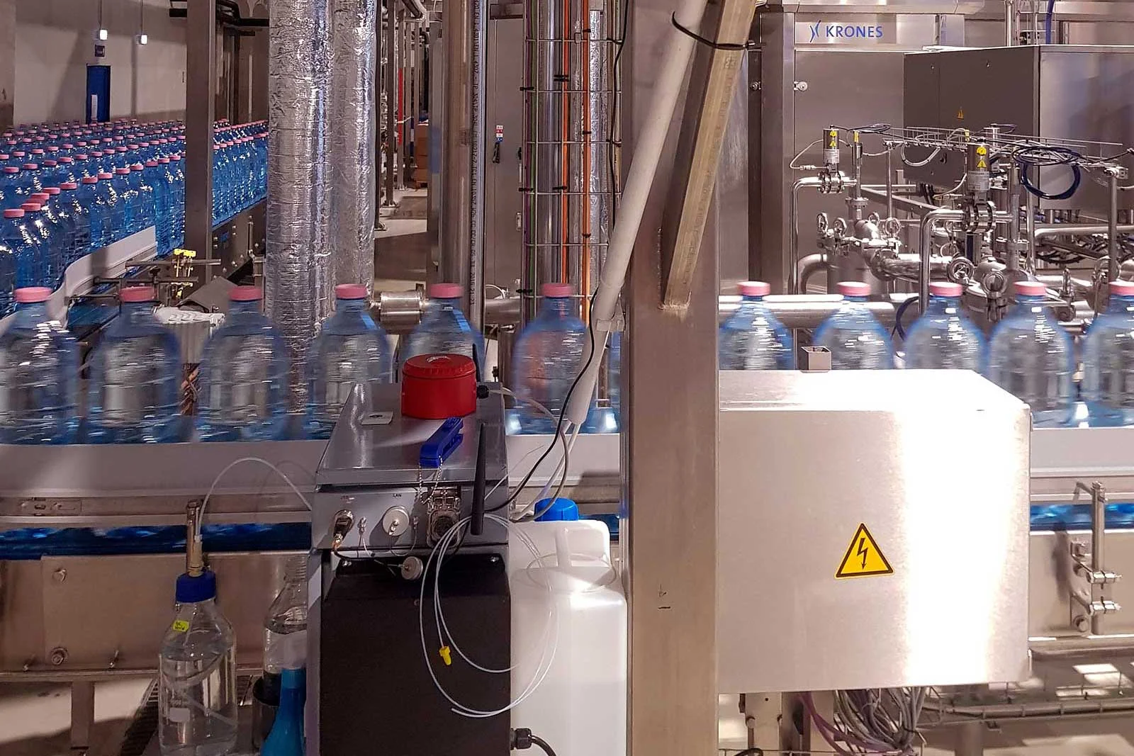 Technician inspecting bottled water production line for quality control