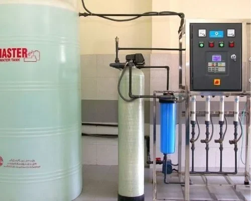 WCSP technicians installing a customized water treatment unit at a community Water Shop, with training and documentation support in progress.